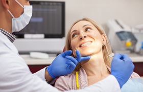 Woman in dental chair during cosmetic consultation.