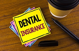Dental insurance written on yellow post it note