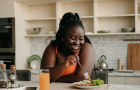 Woman smiling while eating lunch at home