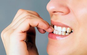 Closeup of patient biting their nails