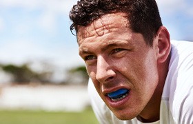 Man wearing blue mouthguard on field