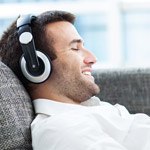 Smiling man with headphones relaxing on couch