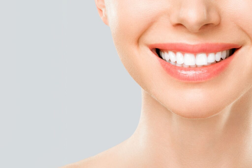 Nose-to-neck view of woman smiling with perfect teeth